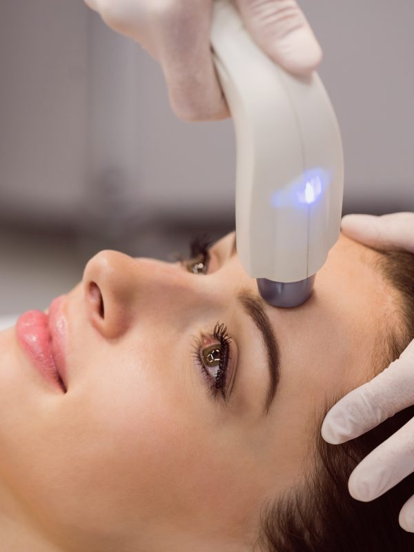 Female patient receiving cosmetic treatment at clinic Séance de traitement esthétique du visage au laser ORIGIN® – Dr Prieur à Cagnes-sur-Mer